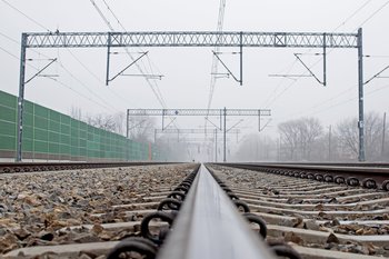 Tor kolejowy i sieć trakcyjna w oddali ekrany akustyczne, fot. Włodzimierz Włoch